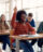 Young woman rasing her hand in class